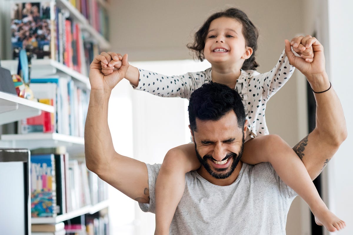 Ein Vater trägt seine Tochter auf den Schultern